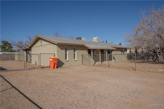 rear view of property with driveway, central AC, fence, and a gate