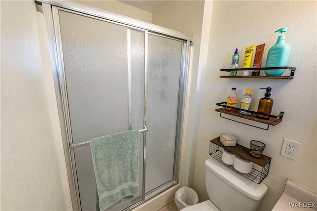 full bathroom featuring toilet and a stall shower