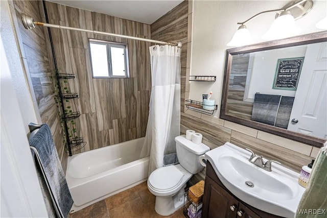 full bathroom with shower / bath combo, toilet, stone finish flooring, vanity, and tile walls