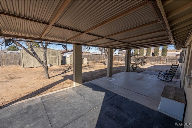 view of patio featuring an outbuilding, a fenced backyard, and a storage unit