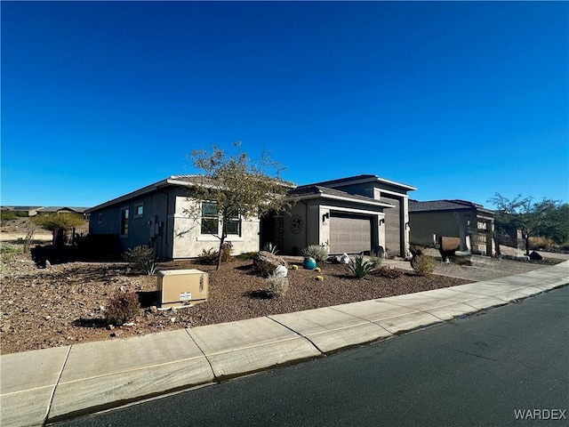 view of front facade with a garage and stucco siding