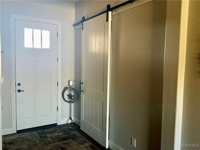 entrance foyer featuring dark wood-style floors and a barn door