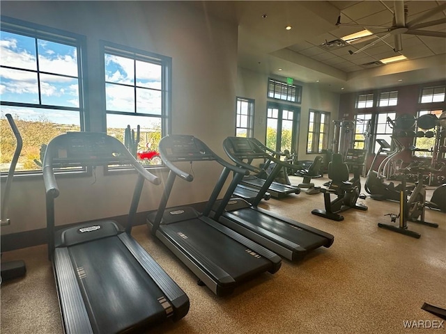 workout area with a healthy amount of sunlight, a high ceiling, and a paneled ceiling