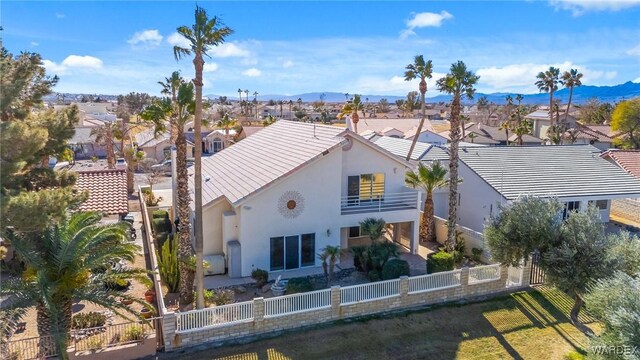 back of property featuring a fenced backyard, a residential view, and stucco siding