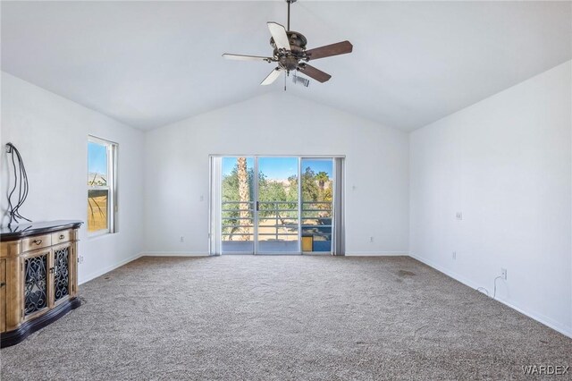 unfurnished living room featuring lofted ceiling, ceiling fan, carpet flooring, and a healthy amount of sunlight