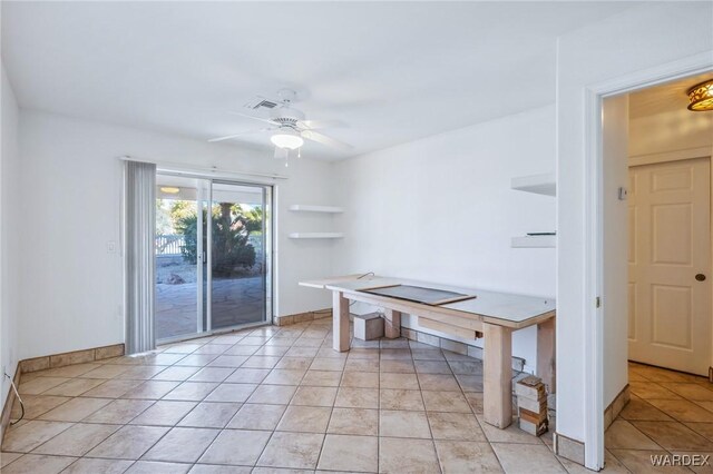 unfurnished office with light tile patterned floors, baseboards, visible vents, and a ceiling fan