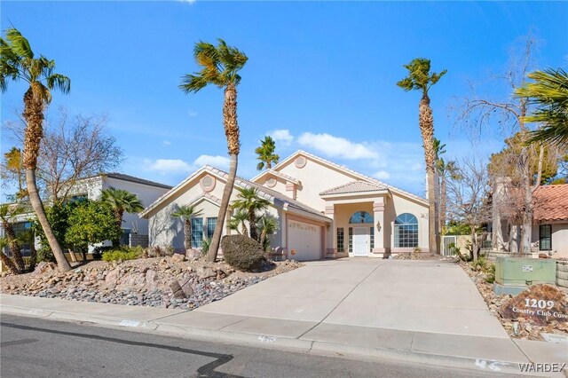 mediterranean / spanish house featuring driveway, stucco siding, a garage, and a tiled roof