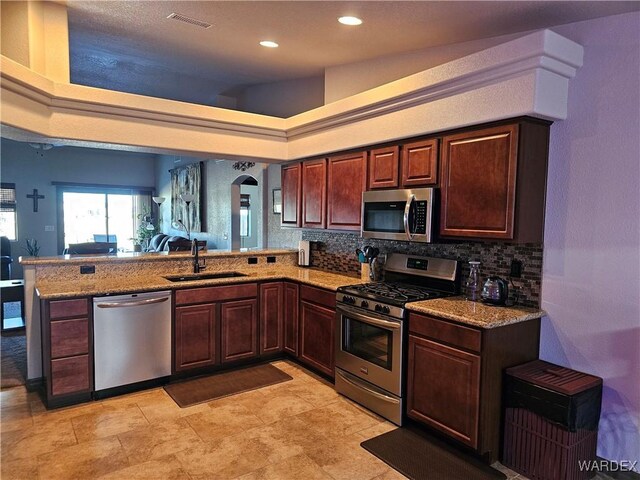 6246 S Vista Laguna Dr, Fort Mohave, AZ 86426 - kitchen with a sink, backsplash, a peninsula, appliances with stainless steel finishes, and visible vents