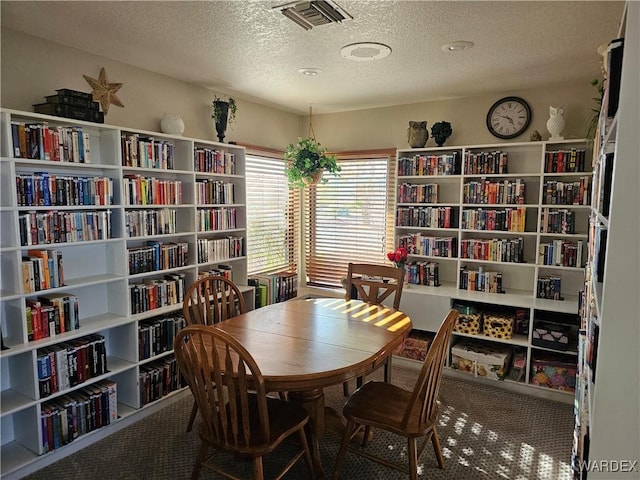 6246 S Vista Laguna Dr, Fort Mohave, AZ 86426 - sitting room featuring bookshelves, visible vents, a textured ceiling, and carpet flooring