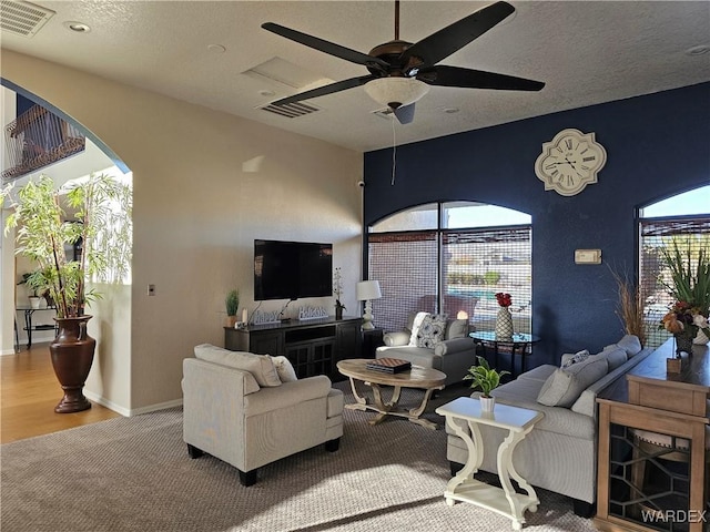6246 S Vista Laguna Dr, Fort Mohave, AZ 86426 - carpeted living area with baseboards, visible vents, arched walkways, and ceiling fan