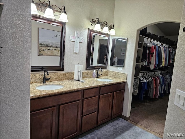 6246 S Vista Laguna Dr, Fort Mohave, AZ 86426 - bathroom featuring a walk in closet, a textured wall, a sink, and double vanity