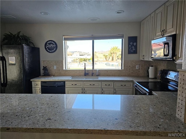 6246 S Vista Laguna Dr, Fort Mohave, AZ 86426 - kitchen with light stone countertops, a sink, black appliances, and tasteful backsplash