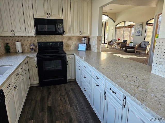 6246 S Vista Laguna Dr, Fort Mohave, AZ 86426 - kitchen featuring black appliances, decorative backsplash, arched walkways, dark wood finished floors, and light stone countertops