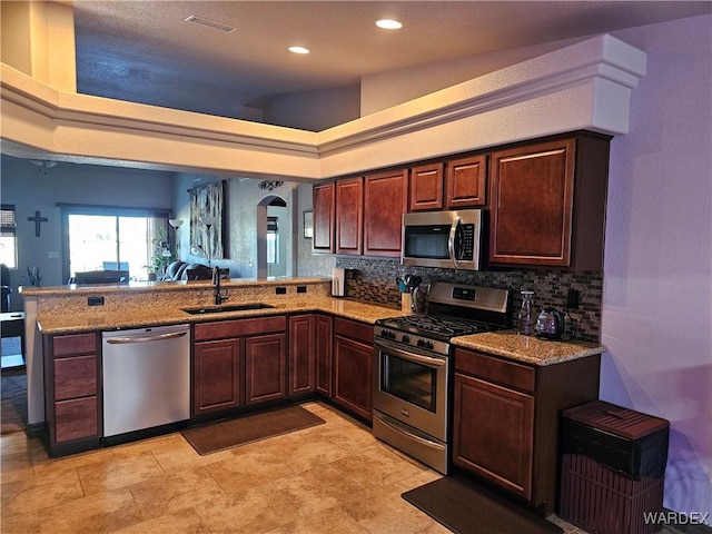6246 S Vista Laguna Dr, Fort Mohave, AZ 86426 - kitchen with stainless steel appliances, backsplash, visible vents, a sink, and a peninsula