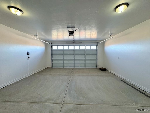 garage with a garage door opener and baseboards