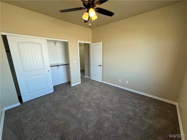 unfurnished bedroom with ceiling fan, baseboards, dark colored carpet, and a closet