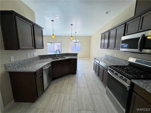 kitchen with decorative light fixtures, a notable chandelier, appliances with stainless steel finishes, a sink, and dark brown cabinets