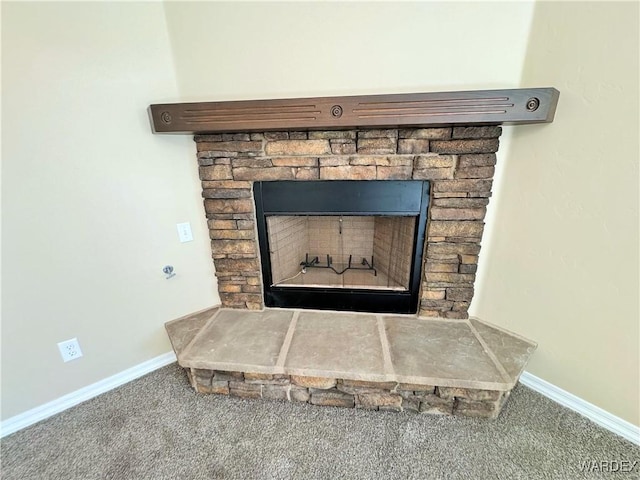 room details featuring carpet floors, a stone fireplace, and baseboards