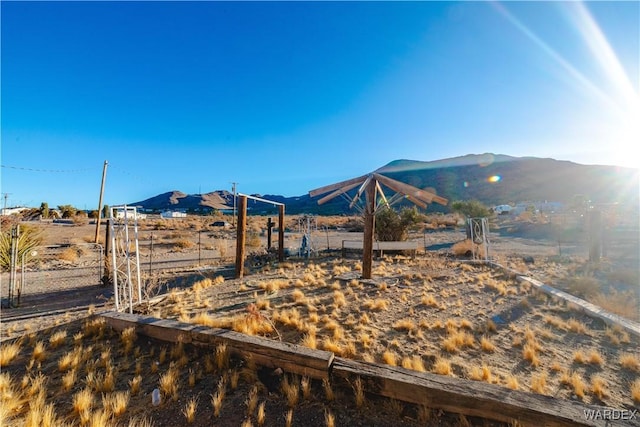 view of yard featuring a rural view, fence, and a mountain view