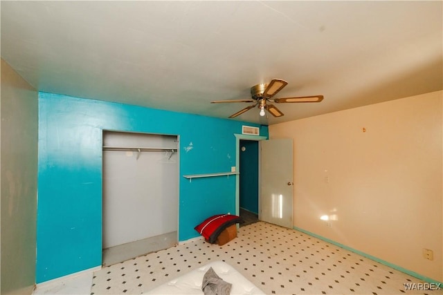 unfurnished bedroom featuring baseboards, ceiling fan, visible vents, and a closet