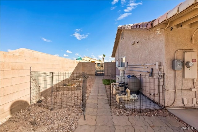 view of property exterior with a gate, fence, and stucco siding