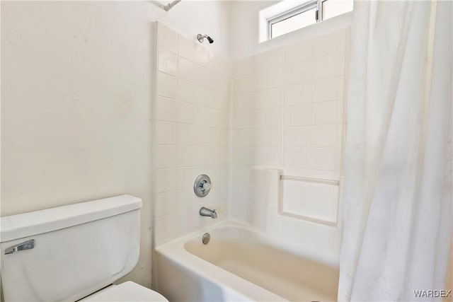 bathroom with shower / bath combo with shower curtain and toilet