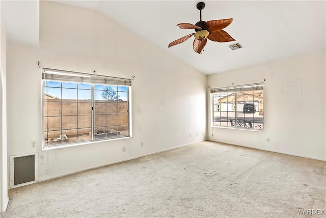 spare room featuring a wealth of natural light, lofted ceiling, visible vents, and carpet