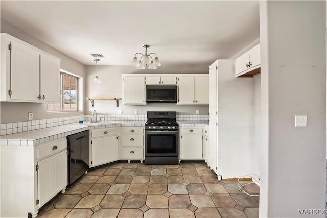 kitchen featuring white cabinets, dishwasher, gas range, hanging light fixtures, and a sink