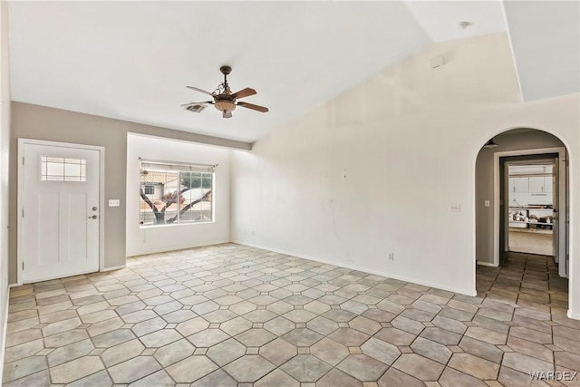 interior space with arched walkways, visible vents, ceiling fan, and baseboards