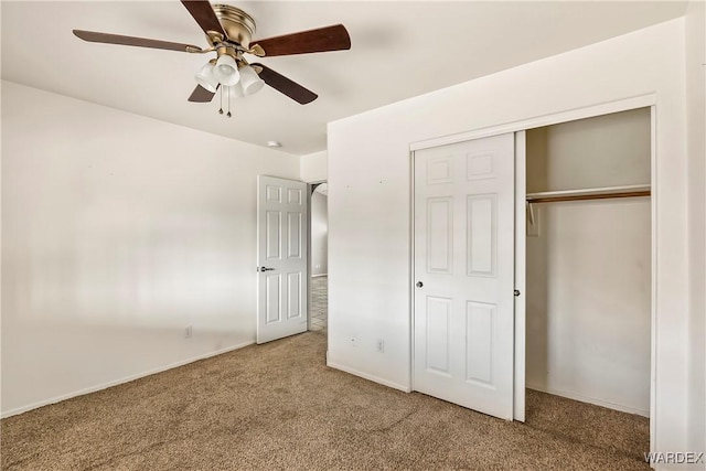 unfurnished bedroom with carpet floors, ceiling fan, baseboards, and a closet