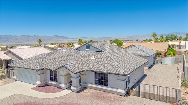 2041 E Sundance Dr, Fort Mohave, AZ 86426 - view of front of house with an attached garage, concrete driveway, a tiled roof, stucco siding, and a mountain view