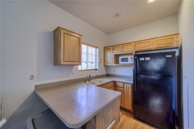 2041 E Sundance Dr, Fort Mohave, AZ 86426 - kitchen with freestanding refrigerator, white microwave, light brown cabinetry, a peninsula, and light wood finished floors