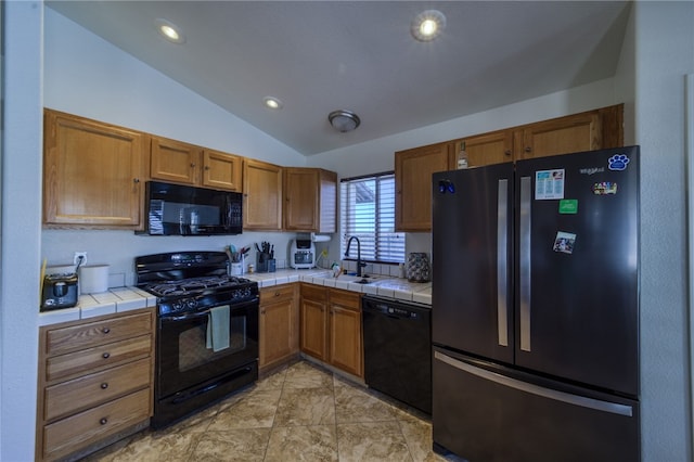 2041 E Sundance Dr, Fort Mohave, AZ 86426 - kitchen featuring black appliances, tile counters, vaulted ceiling, brown cabinetry, and recessed lighting