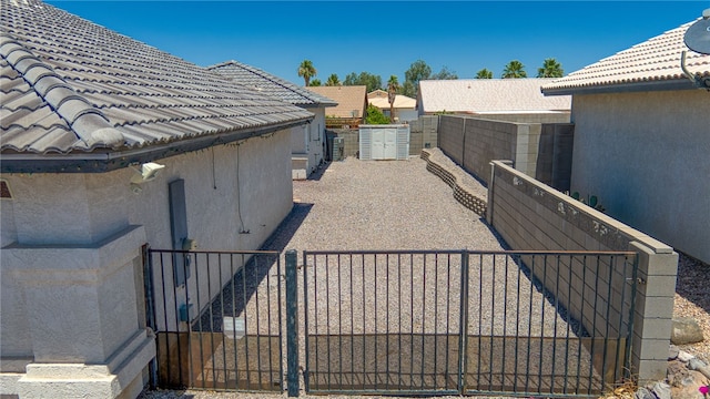 2041 E Sundance Dr, Fort Mohave, AZ 86426 - view of side of property with a gate, stucco siding, and a tiled roof