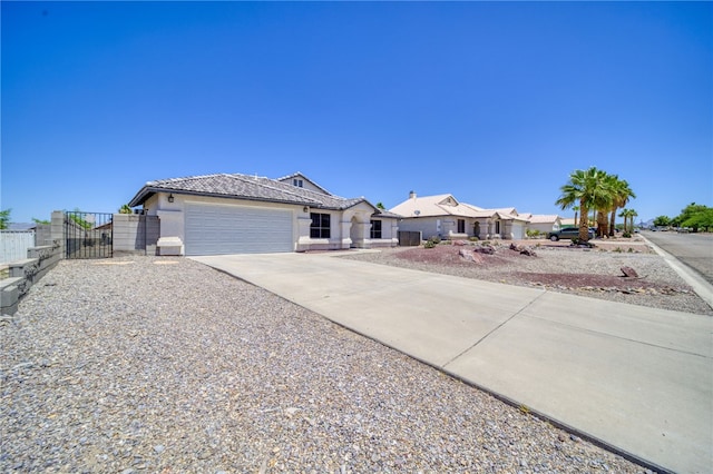 2041 E Sundance Dr, Fort Mohave, AZ 86426 - single story home with driveway, a garage, a gate, stucco siding, and a tiled roof
