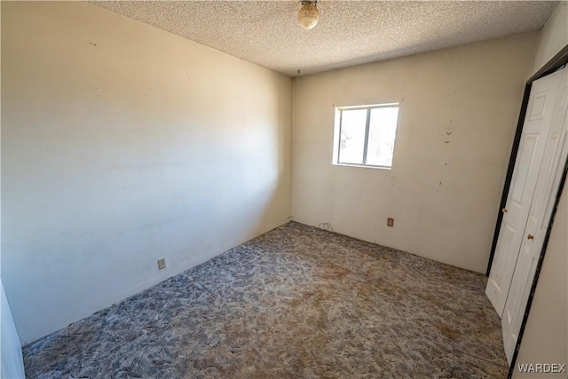 unfurnished bedroom with a textured ceiling and carpet flooring