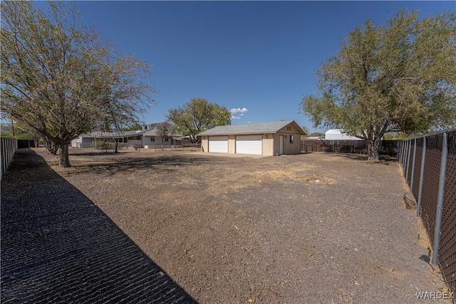 exterior space featuring a garage, fence, and an outdoor structure