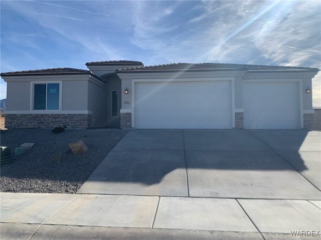 view of front of house featuring a garage, driveway, stone siding, and stucco siding