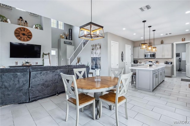 dining area with light tile patterned floors, recessed lighting, visible vents, stairway, and a chandelier