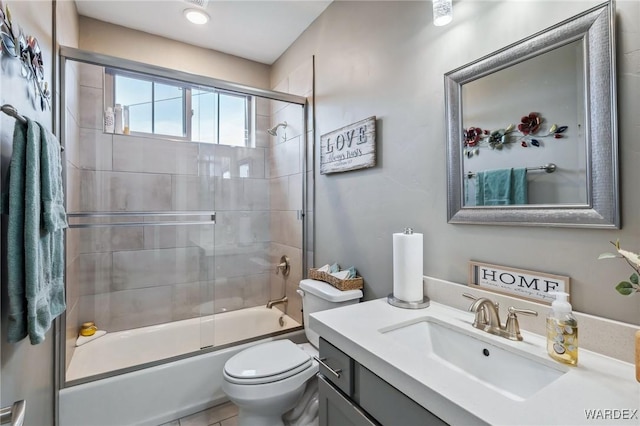 full bath with toilet, enclosed tub / shower combo, and vanity