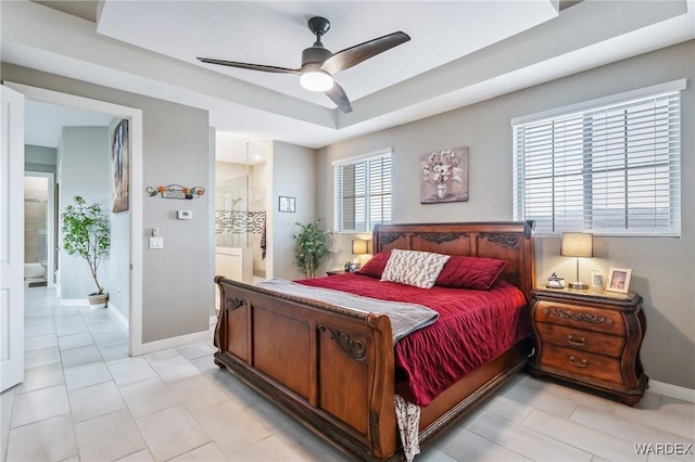 bedroom featuring a ceiling fan, a raised ceiling, connected bathroom, and baseboards