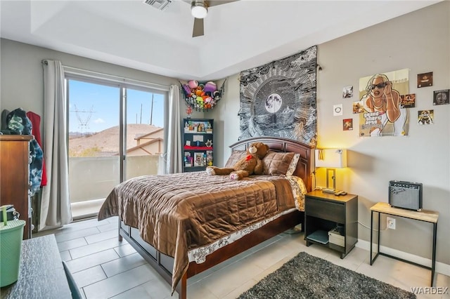 bedroom with a tray ceiling, visible vents, ceiling fan, access to outside, and baseboards