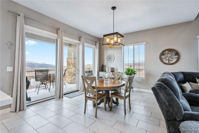 dining area with baseboards, a mountain view, and a notable chandelier