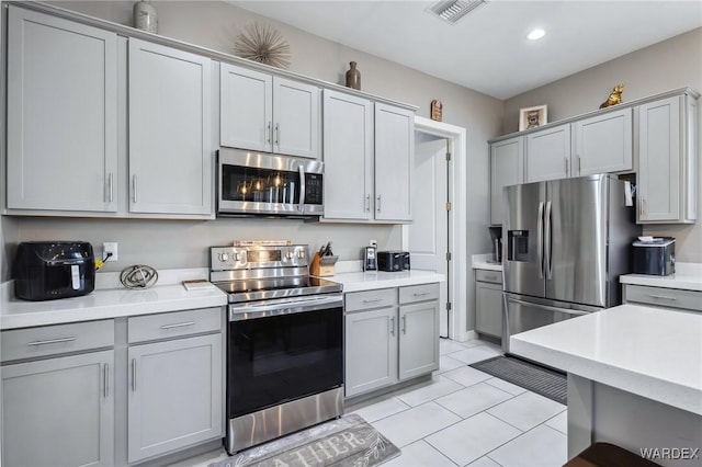 kitchen with gray cabinets, visible vents, stainless steel appliances, and light countertops