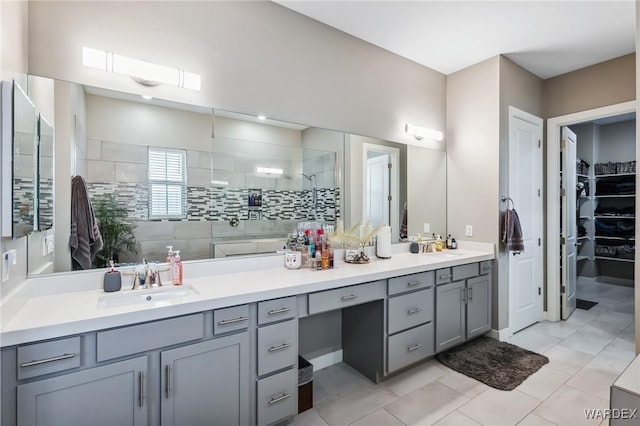 bathroom with tile patterned flooring, a spacious closet, vanity, and walk in shower