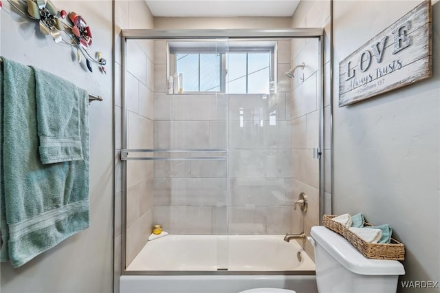 bathroom featuring enclosed tub / shower combo and toilet