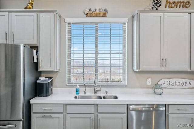 kitchen with light countertops, appliances with stainless steel finishes, and a sink