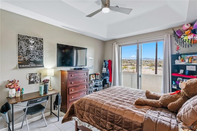 bedroom with access to exterior, a raised ceiling, light tile patterned flooring, and ceiling fan