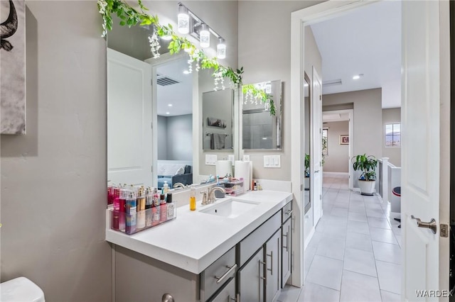 ensuite bathroom featuring tile patterned flooring, visible vents, vanity, and ensuite bath