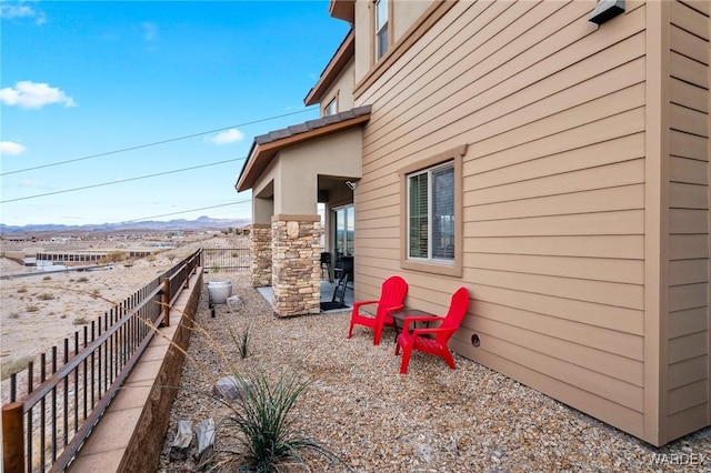 view of property exterior with a patio area, fence, and a mountain view